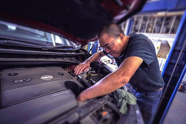 auto mechanic changing oiling in car