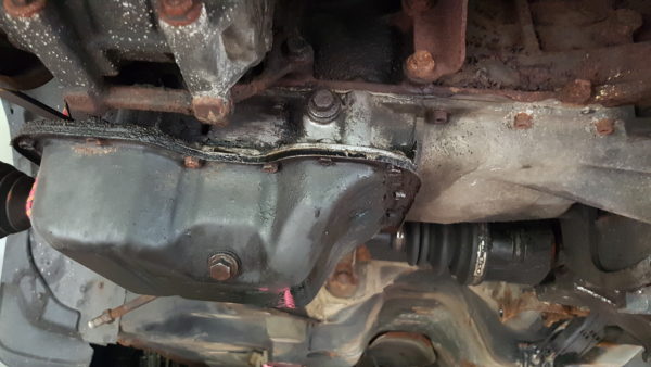 oil pan under a car during an oil change